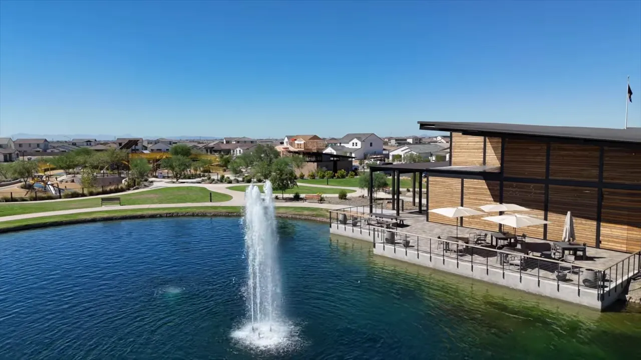 Community lake with fountain patio seating and clubhouse building