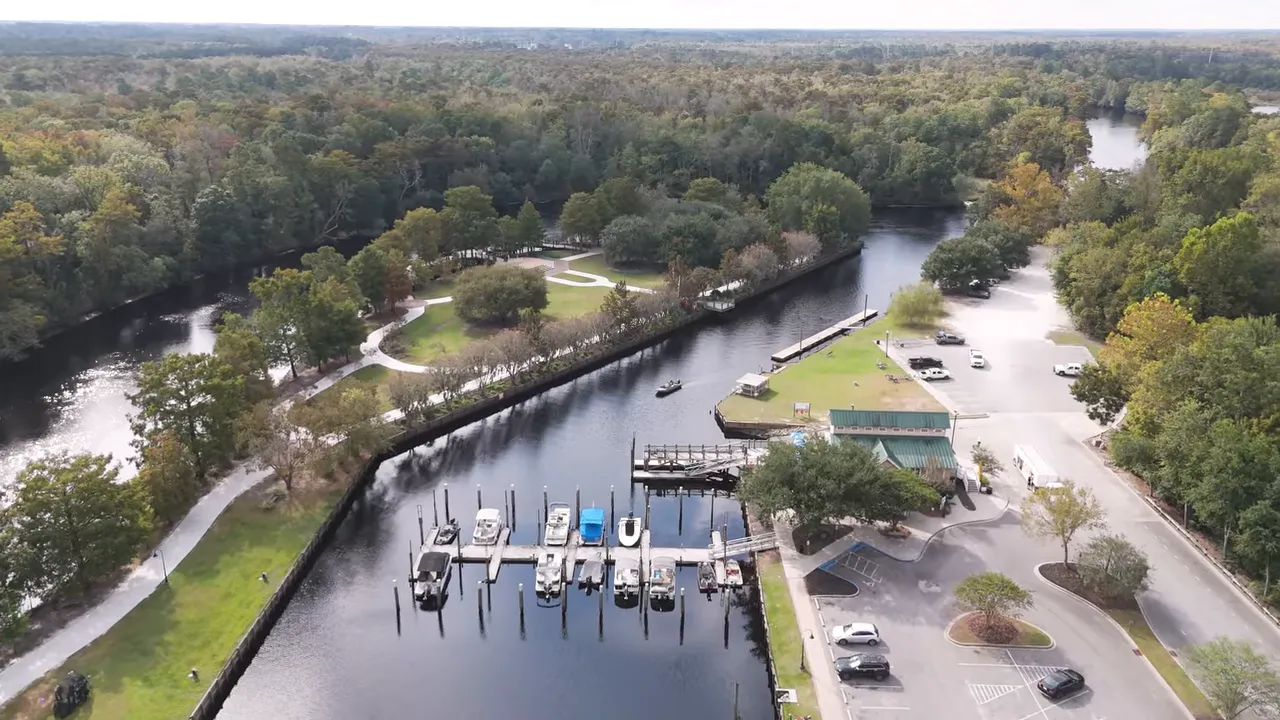 Aerial view of Conway riverfront marina and Riverwalk showing docks, boats, and park