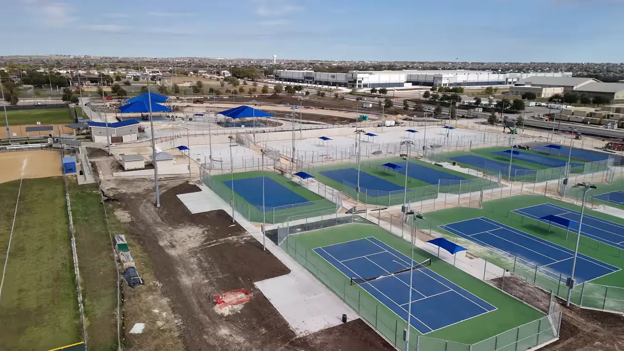 Aerial view of blue tennis and pickleball courts with on screen cost text