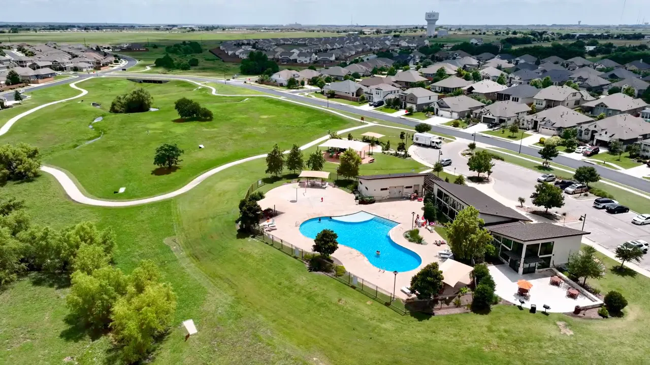 Aerial view of community pool buildings walking paths and open green space