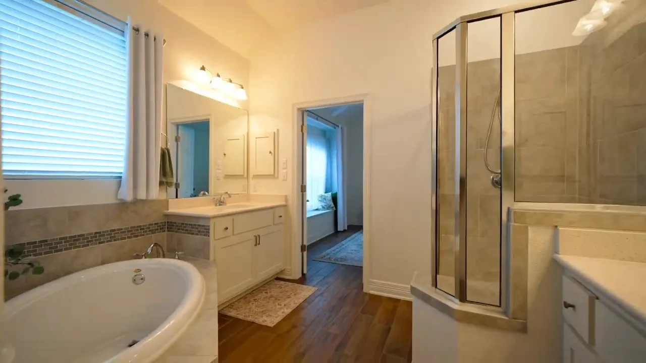Primary bathroom with vanity soaking tub and glass shower