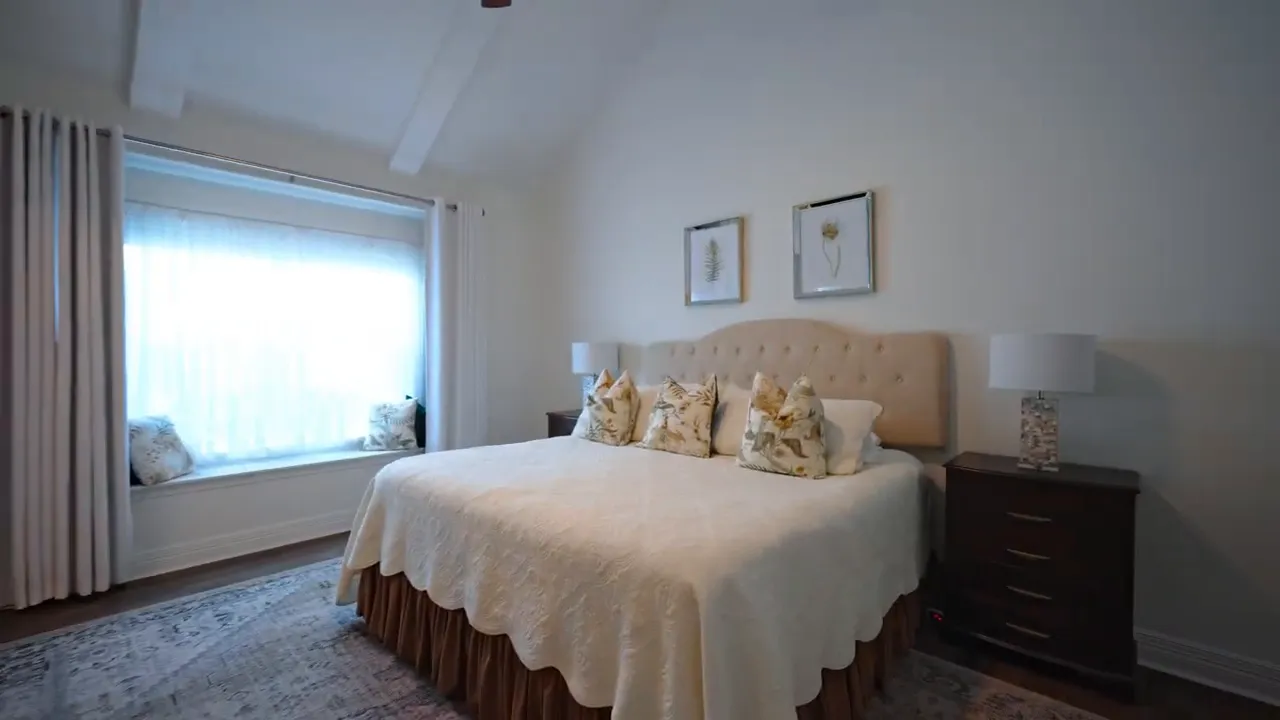 Primary bedroom with bed bay window and vaulted ceiling