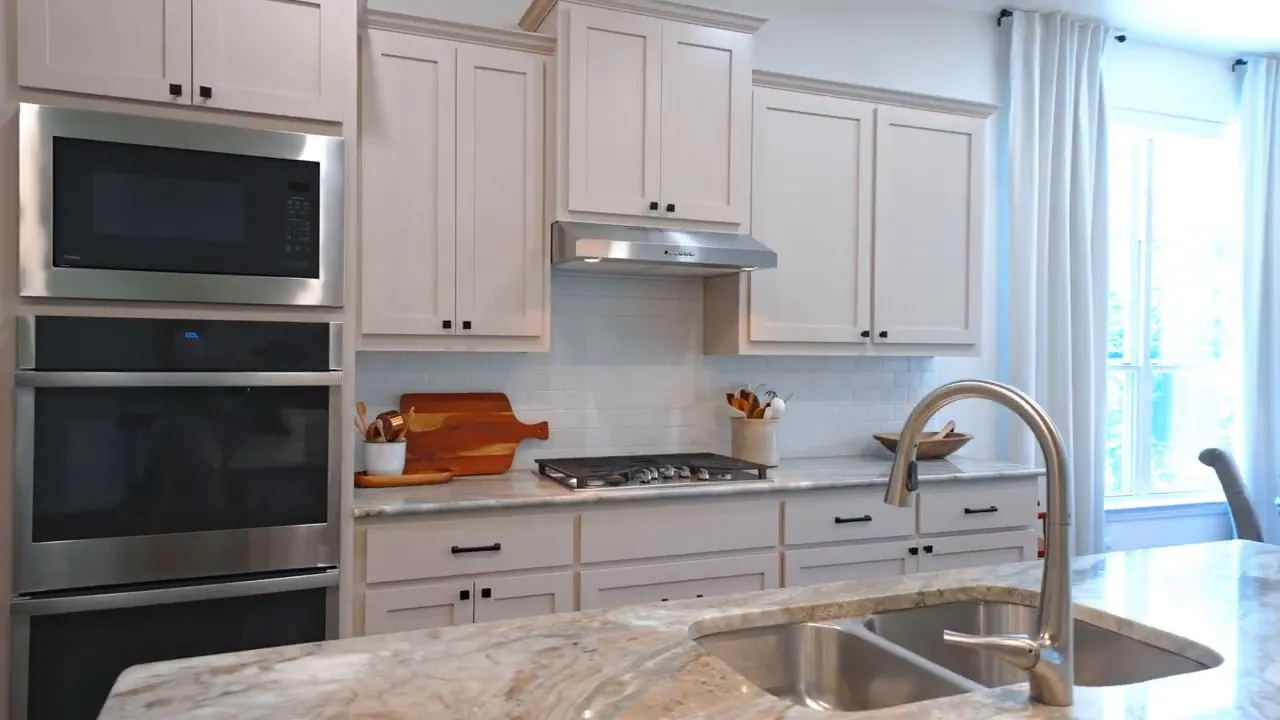 Wide kitchen view showing cabinets sink island and dining area beyond