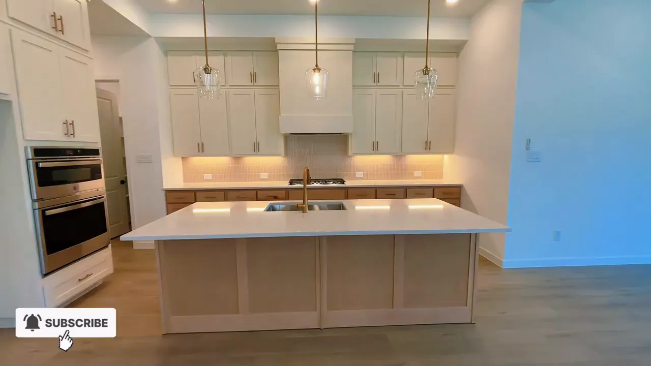 Kitchen island centered in front of tall cabinets and pendant lights