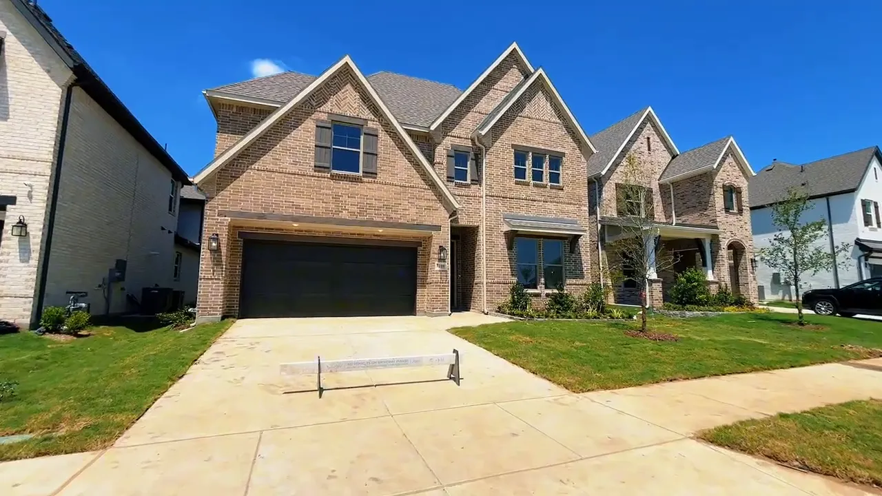 Front exterior of a two story brick home with driveway and garage