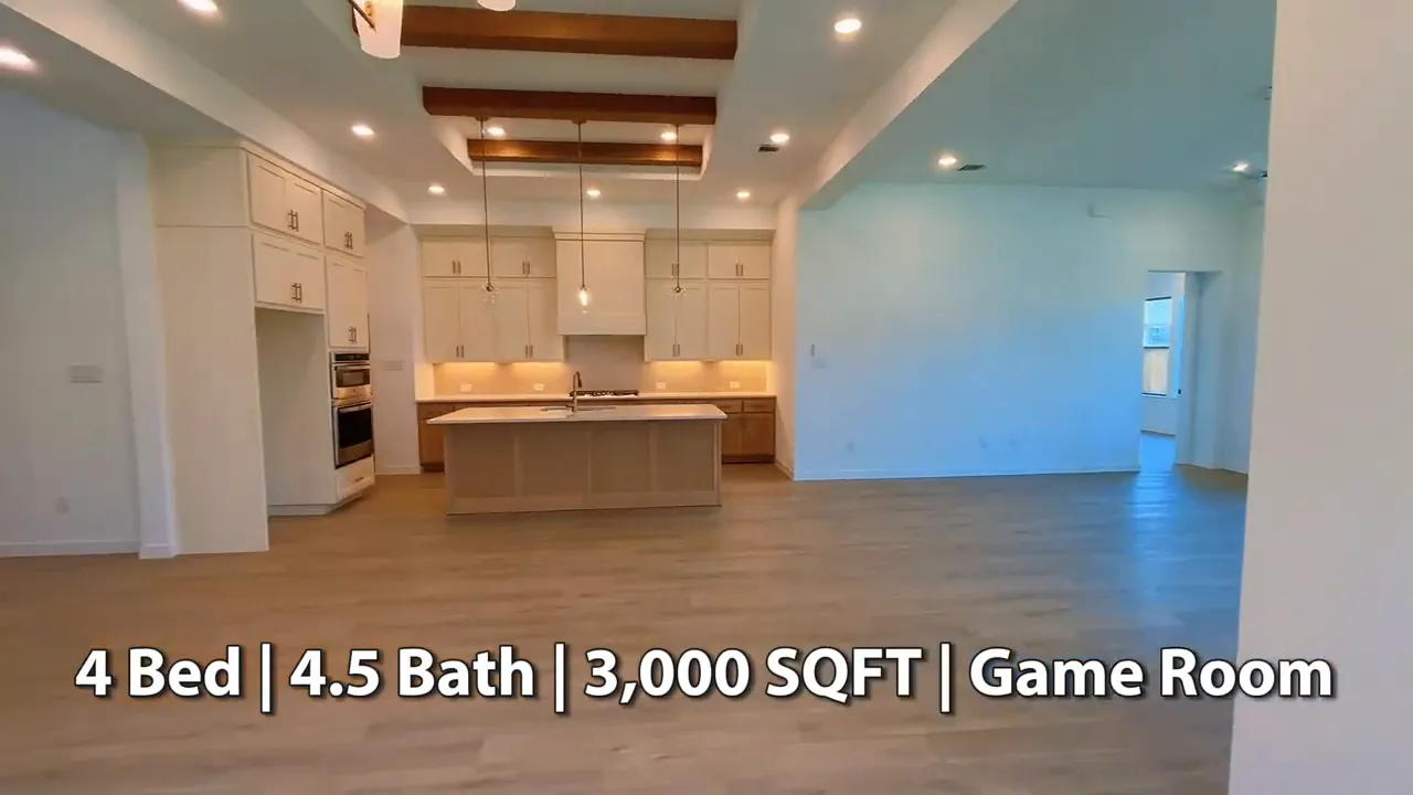 Wide open living area and kitchen with exposed ceiling beams and large island