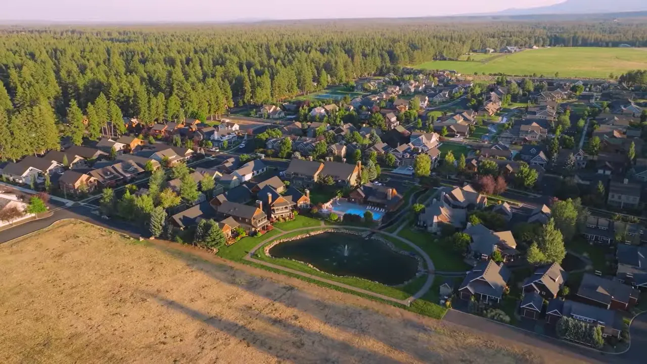 Aerial view of a Southern Oregon neighborhood with homes and a pond