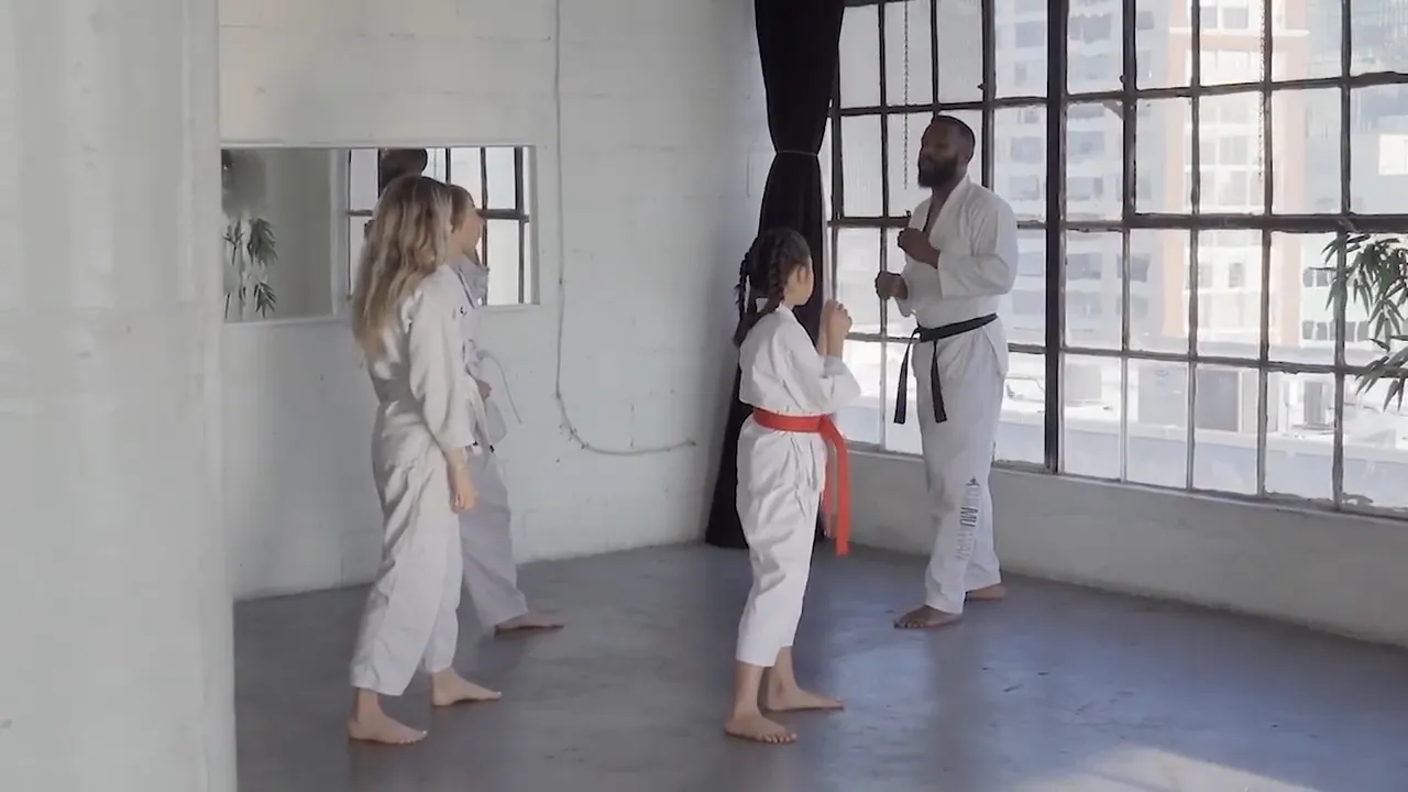 Children in a karate class practicing moves in a studio with large windows
