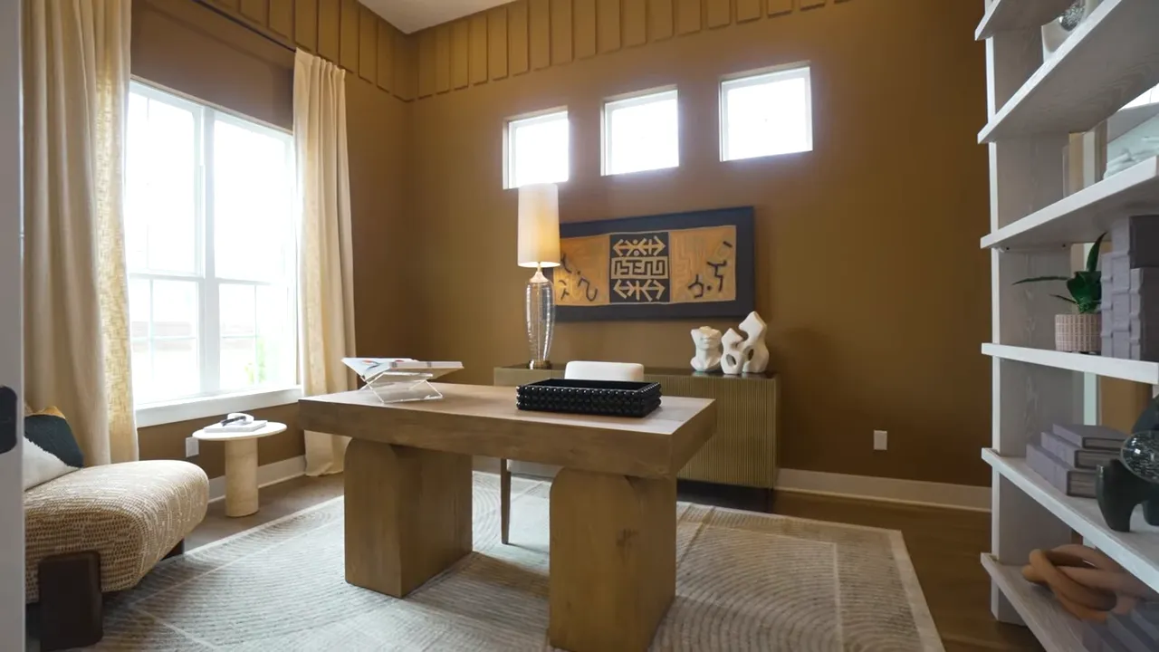 Study with built in shelving desk and high windows