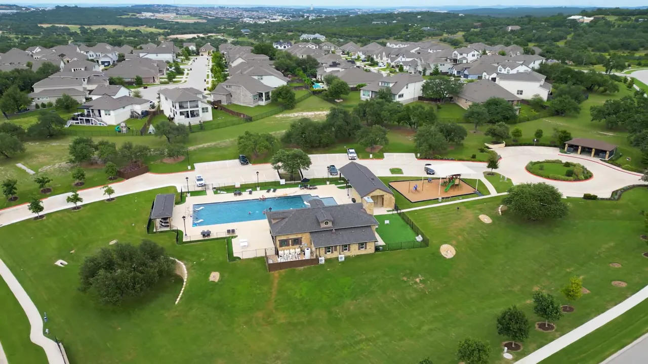 Aerial view of neighborhood pool and surrounding homesites