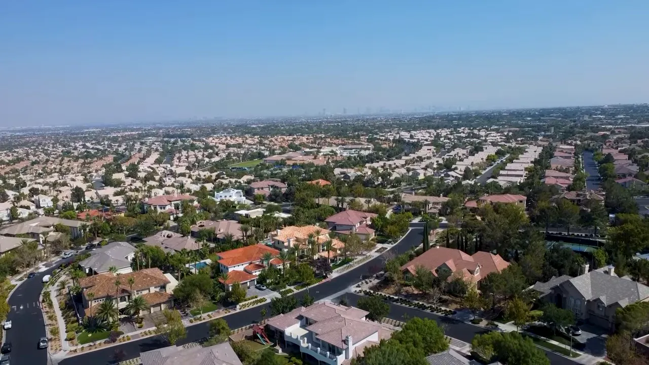 Aerial view of several blue pickleball courts beside neighborhood homes