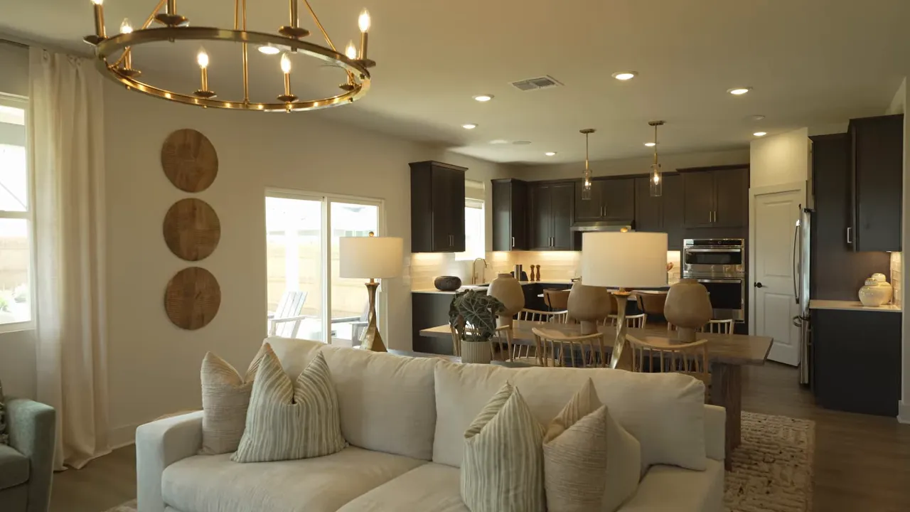 Model home kitchen with dark cabinets island pendant lights and bar stools