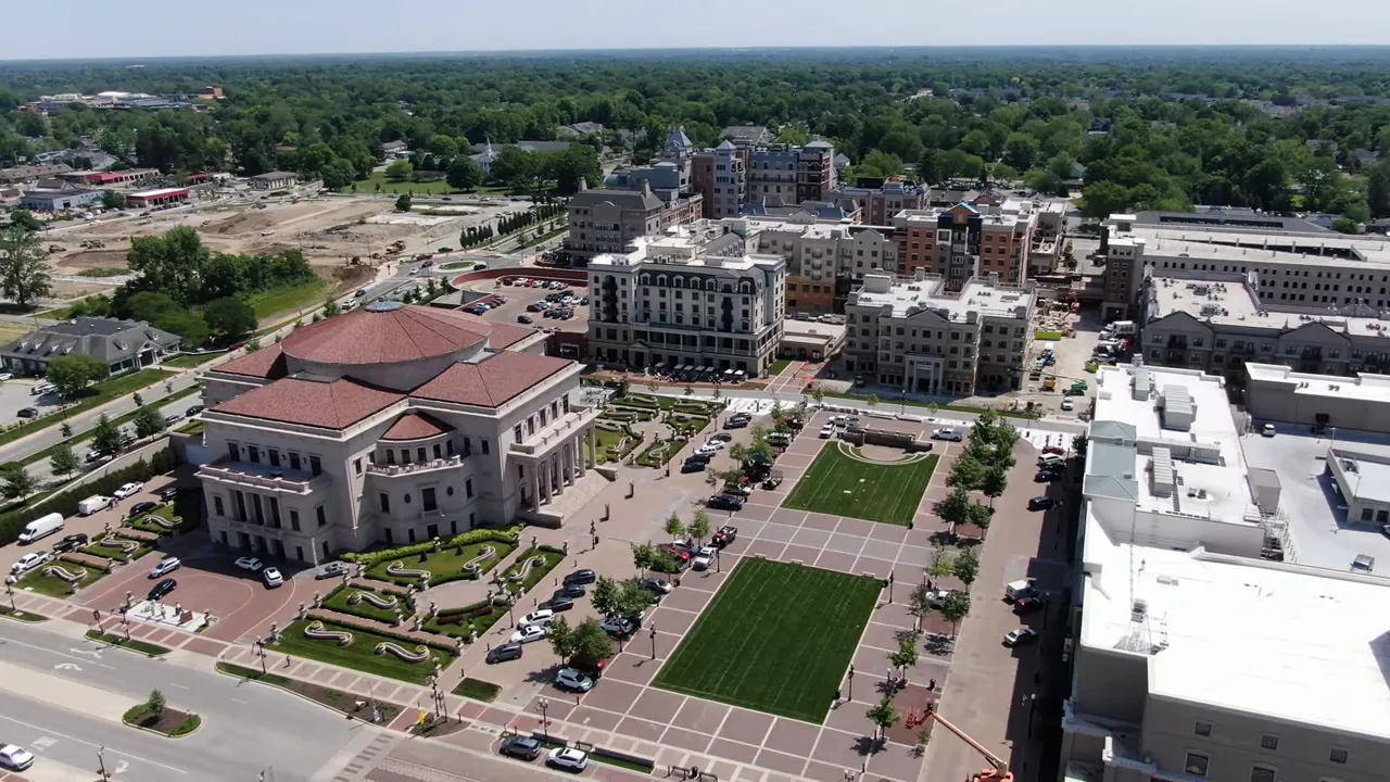 High-resolution aerial shot of Carmel's Arts & Design District plaza, green lawns, and surrounding mixed-use buildings.