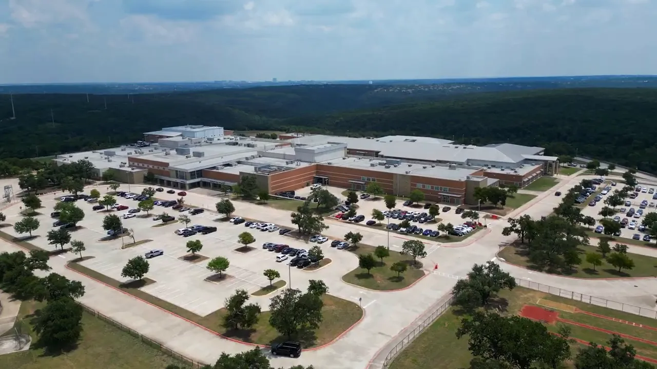 aerial view of a large school campus with parking lots and athletic areas in Cedar Park