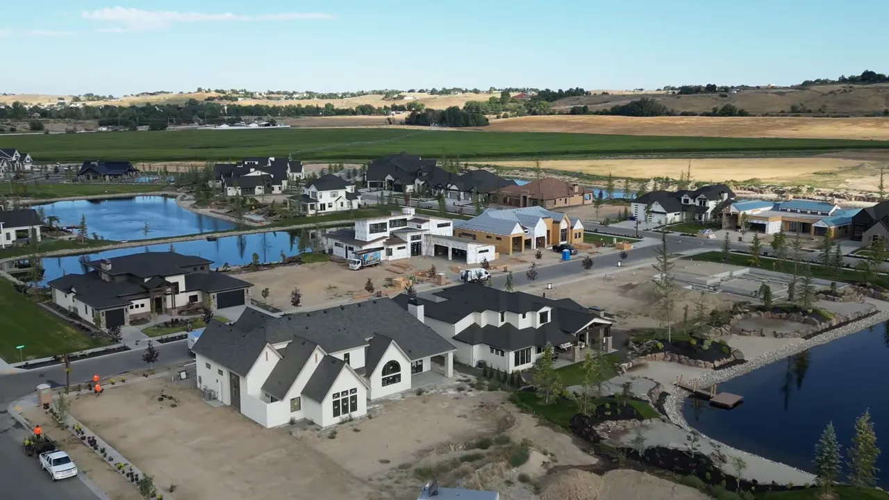 Aerial view of new construction homes clustered around lakes and a community center in Treasure Valley, Idaho