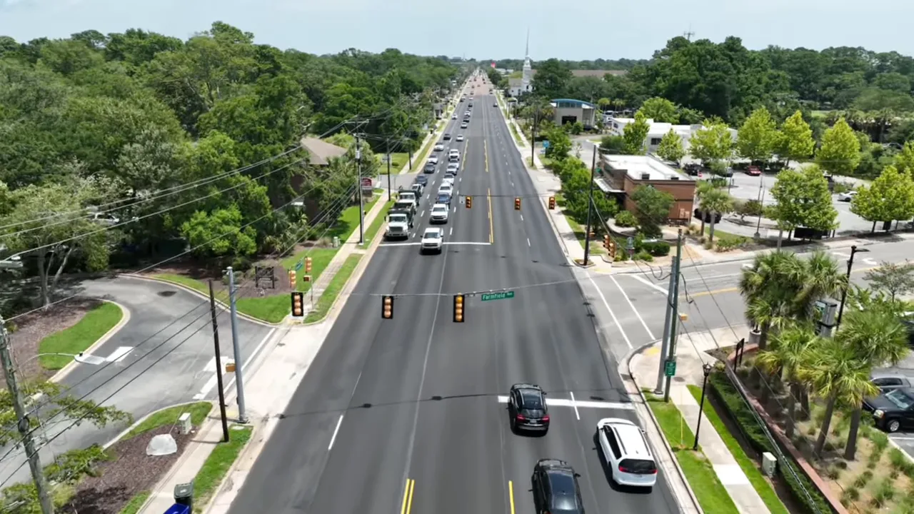 High-quality aerial view of a wide main street with queued cars, traffic lights, sidewalks and nearby businesses