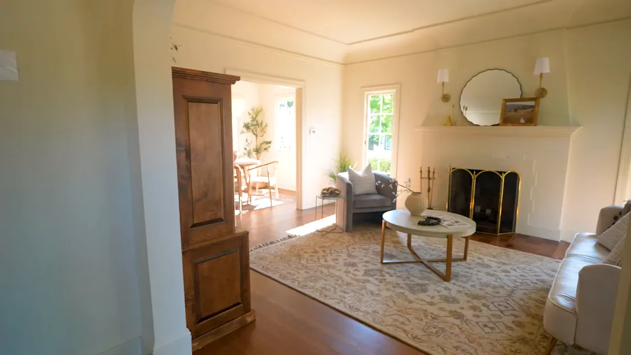 Bright living room with fireplace, arched doorway, hardwood floors and period details in a Burlingame Terrace home