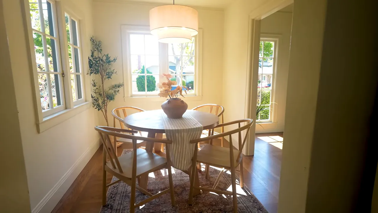 Sunlit dining nook with round table, wooden chairs, pendant light and multi‑pane windows in a Burlingame Terrace home
