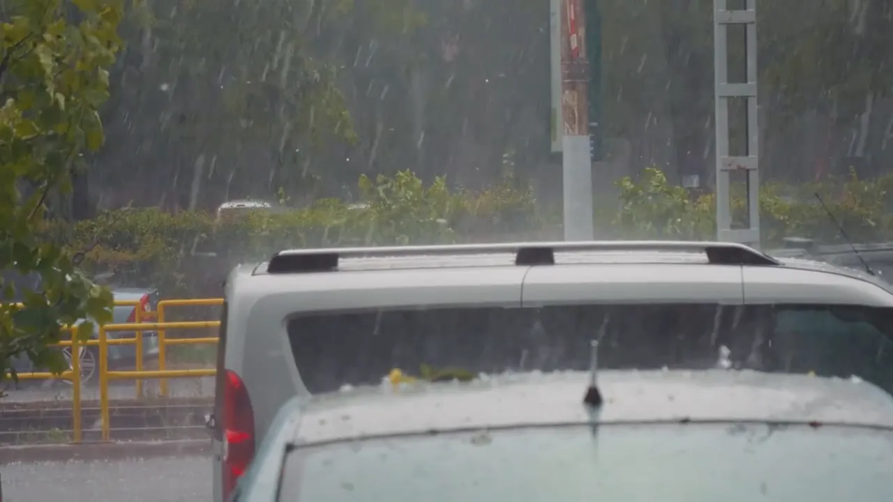 Hail falling around parked vehicles during a storm