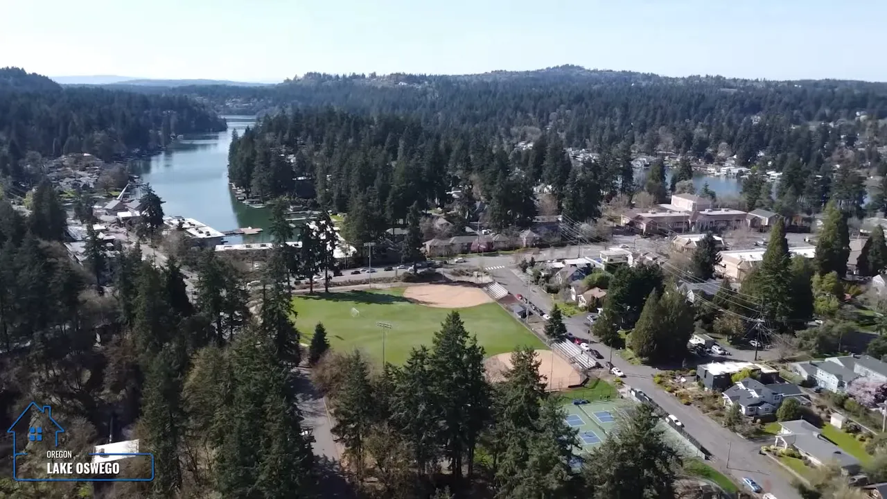 Aerial view over Lake Oswego neighborhood with tree canopy and lakefront scenery