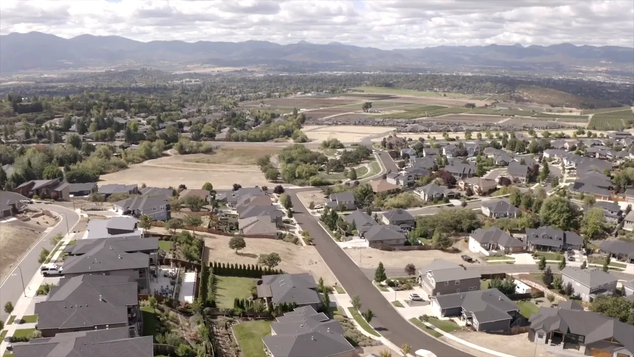 Aerial view of Southern Oregon neighborhood and valley with distant mountains