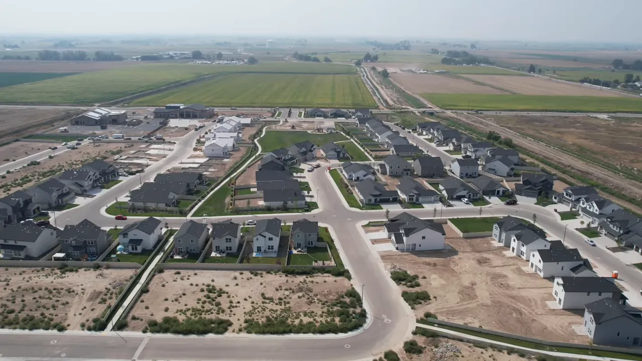 Aerial view of a suburban neighborhood with homes and new development lots