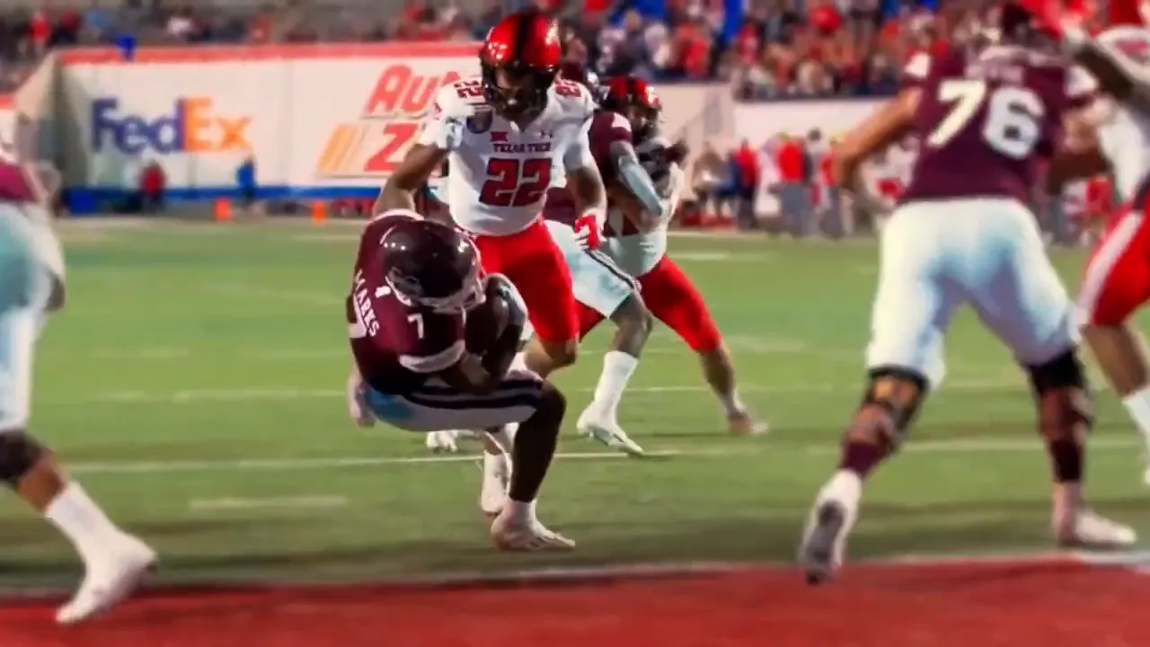 Texas Tech football player making a play near the end zone during a game, stadium crowd visible in background.