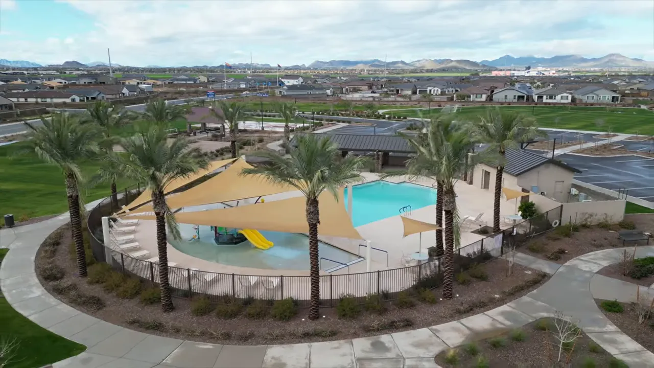 Aerial view of community pool with shade structures and palm trees at Bella Vista Farms