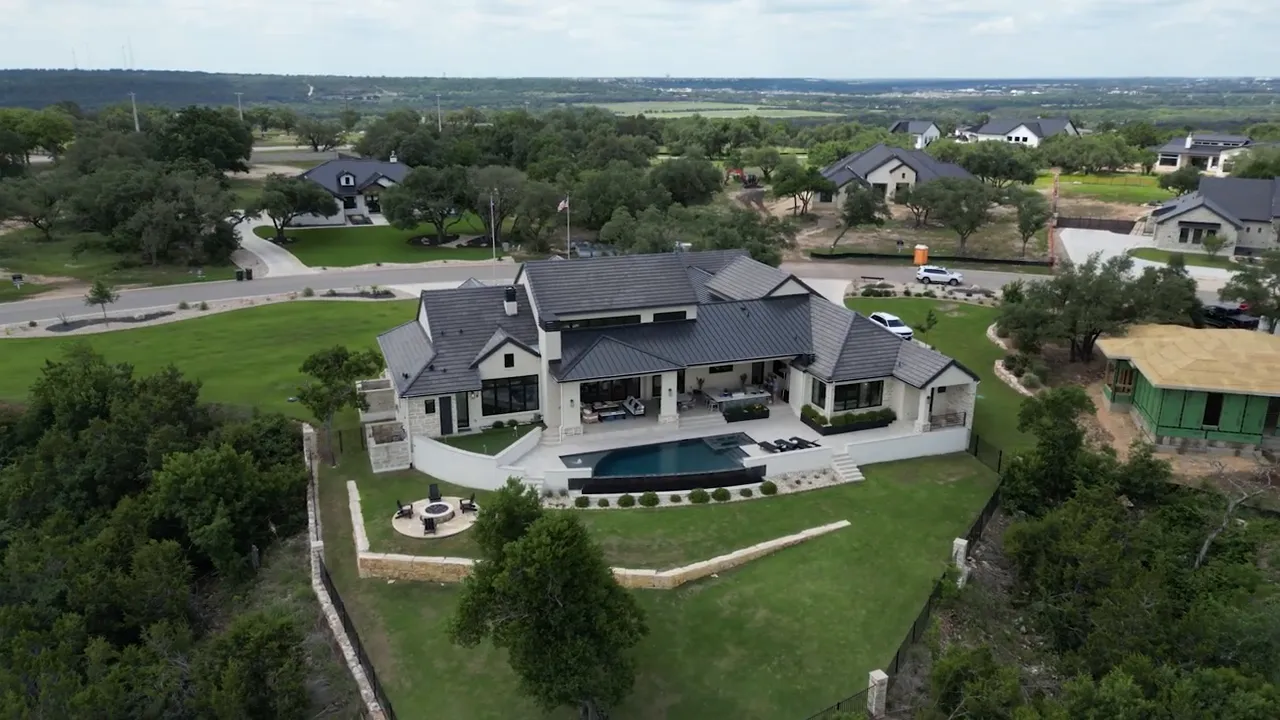 Aerial view of custom home pool lawn and surrounding trees