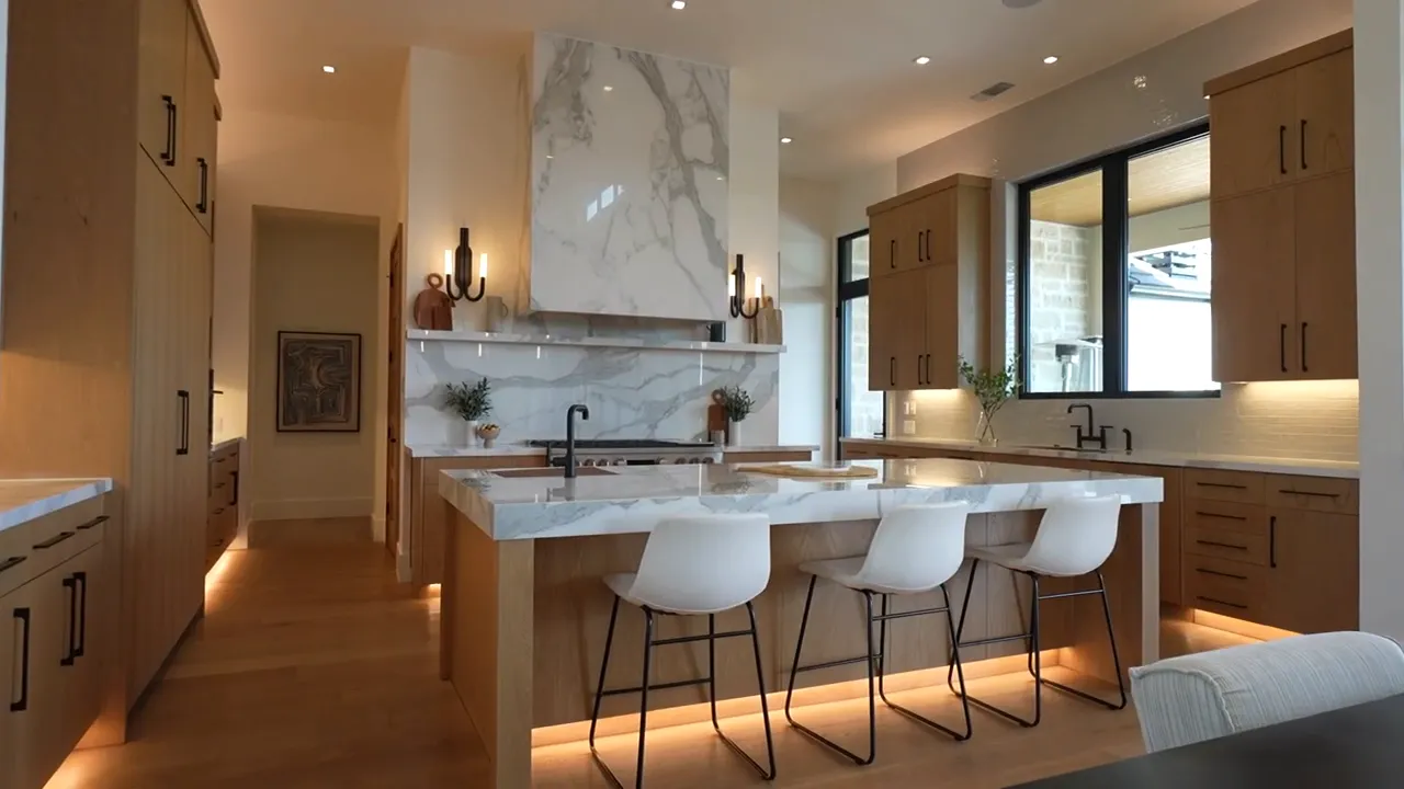 Large kitchen island with bar stools wood cabinets and pendant lights