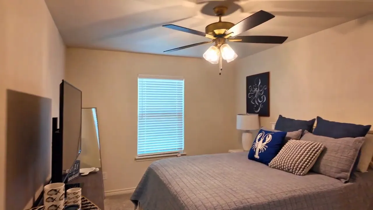 Secondary bedroom with bed ceiling fan window and dresser