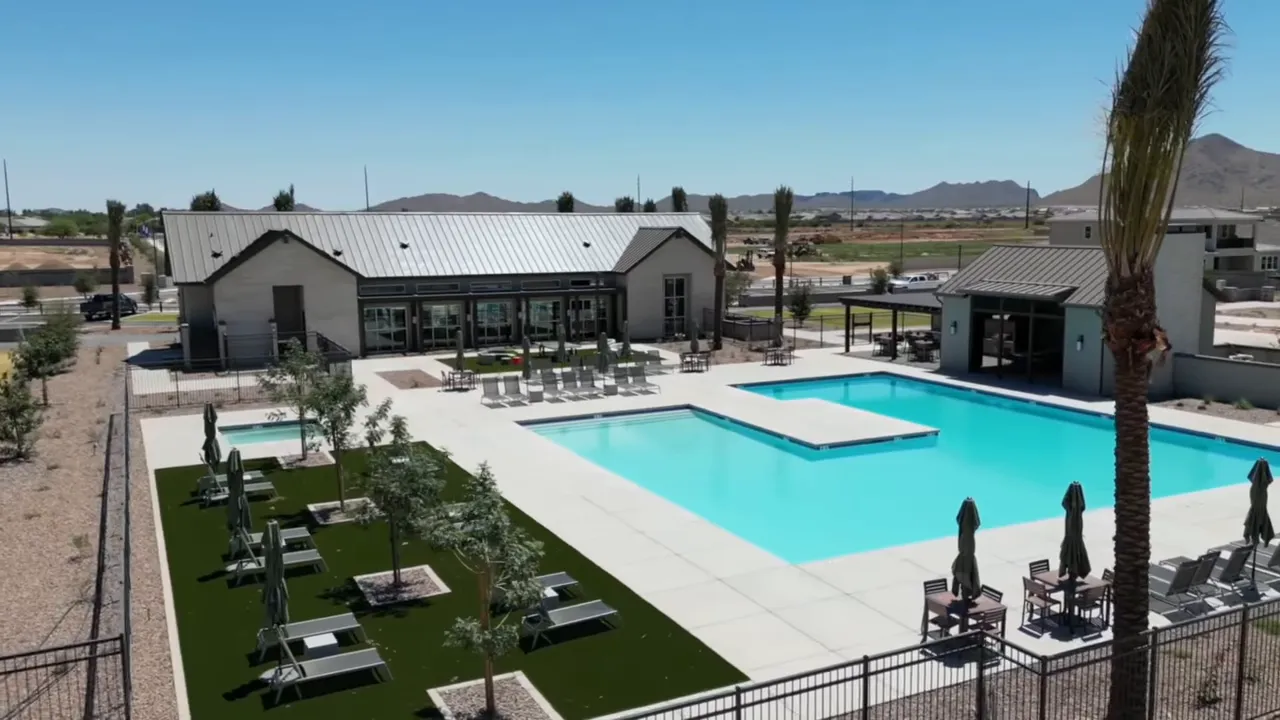 Large community pool with loungers and clubhouse buildings