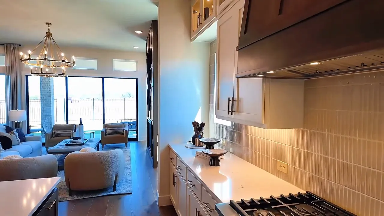 Kitchen entertaining zone with gas cooktop and seating area overlooking the living room in a new construction home