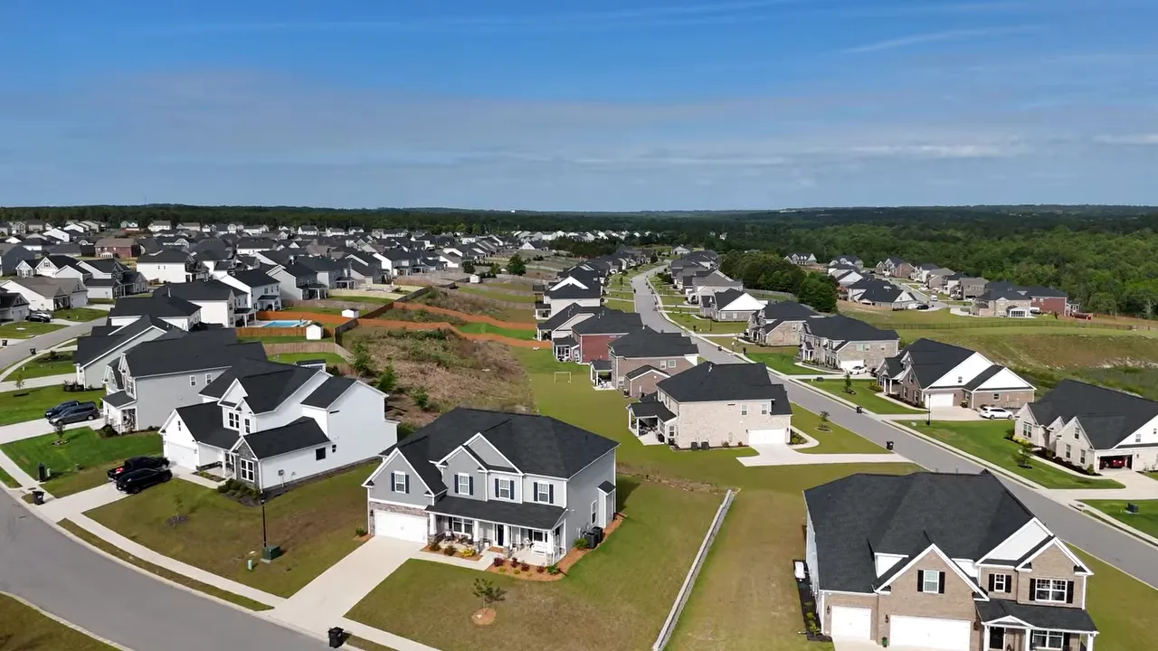 Aerial view of homes near a large lake surrounded by trees