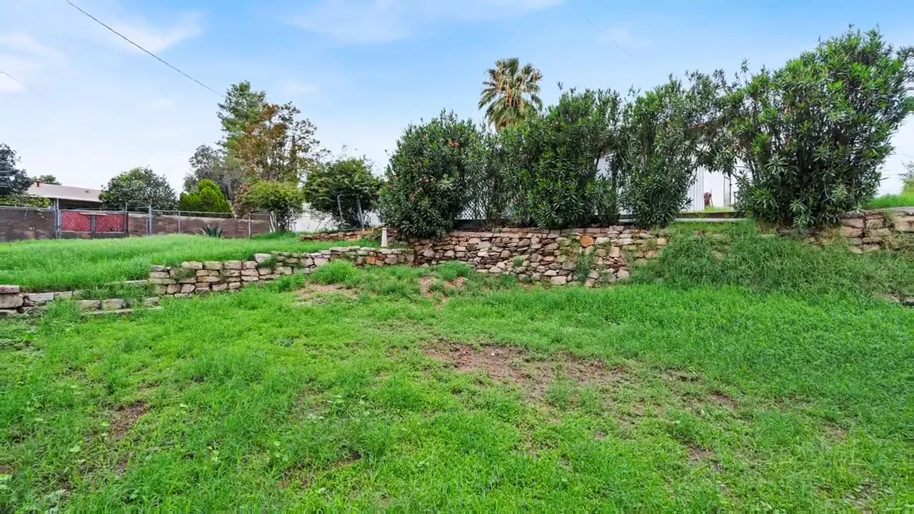 Wide view of the backyard lawn and stone landscaping at 832 West Paxton Avenue in Miami Arizona