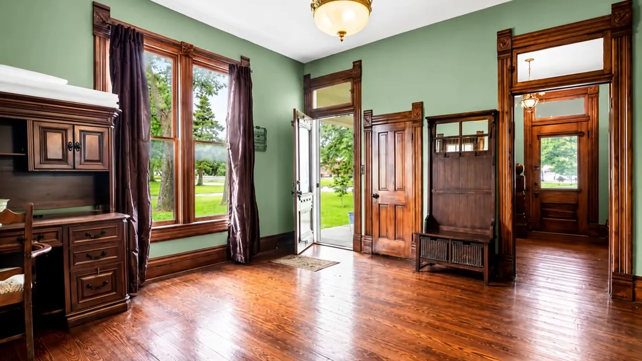 Historic home interior with dark wood trim tall windows and hardwood floors