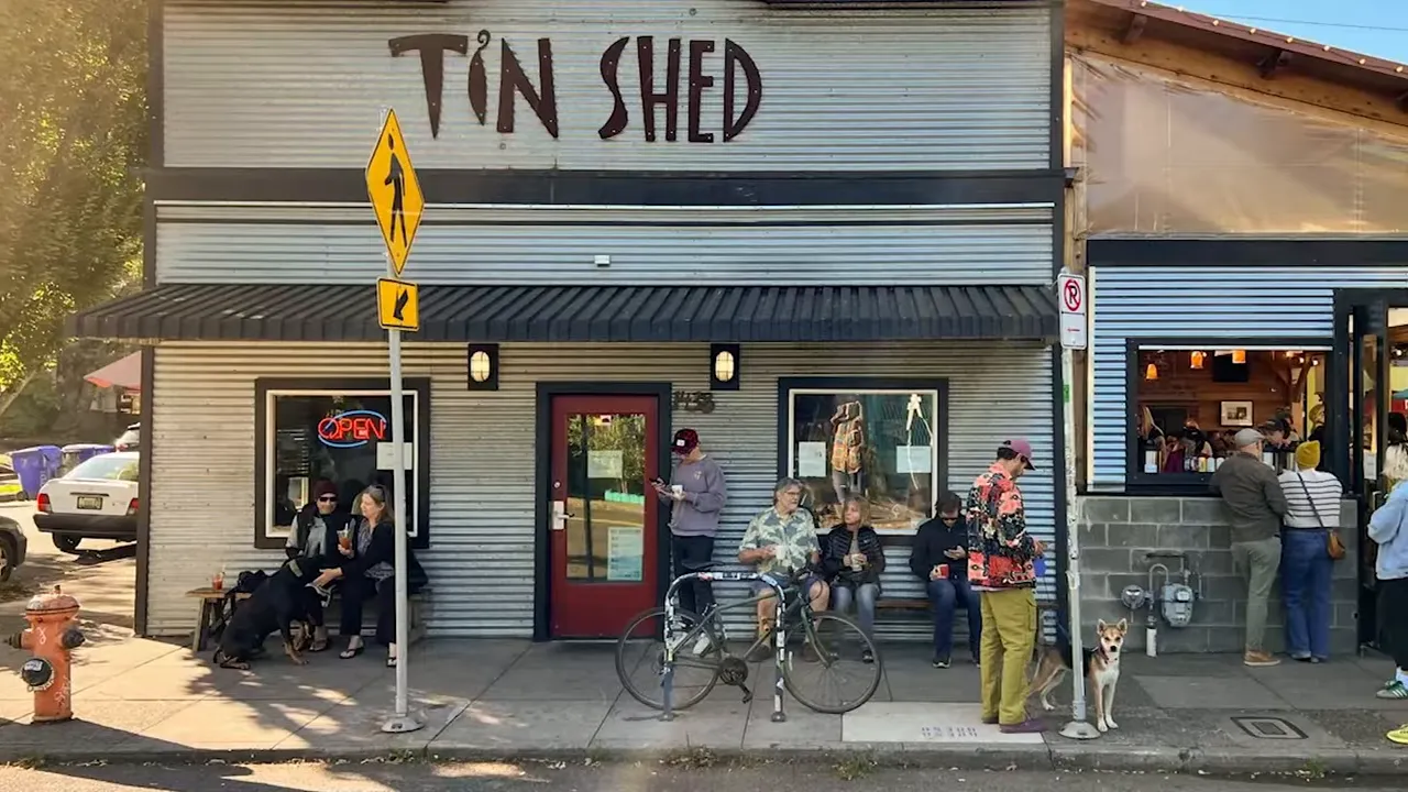 Tin Shed restaurant exterior with people standing near the entrance and bicycles on the sidewalk