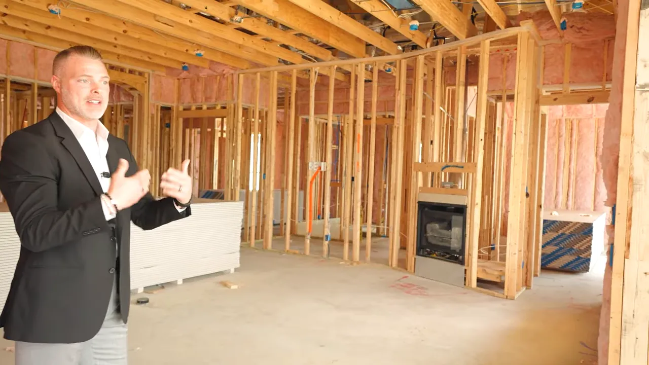 Pre-drywall walkthrough wide shot showing exposed wood framing and interior wall layout