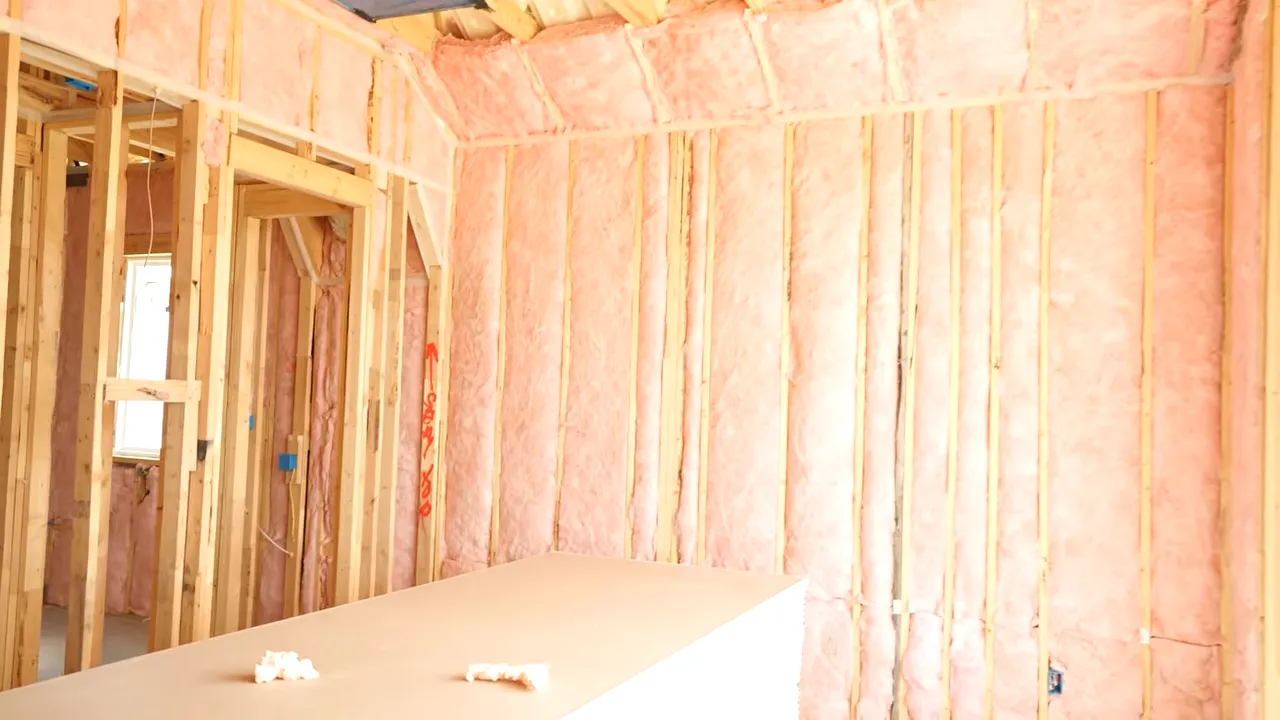 Close view of open wall framing and insulation in an unfinished DFW home before drywall