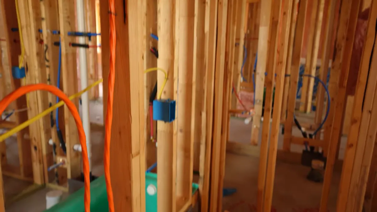 Organized jobsite with exposed framing and protective covers before drywall