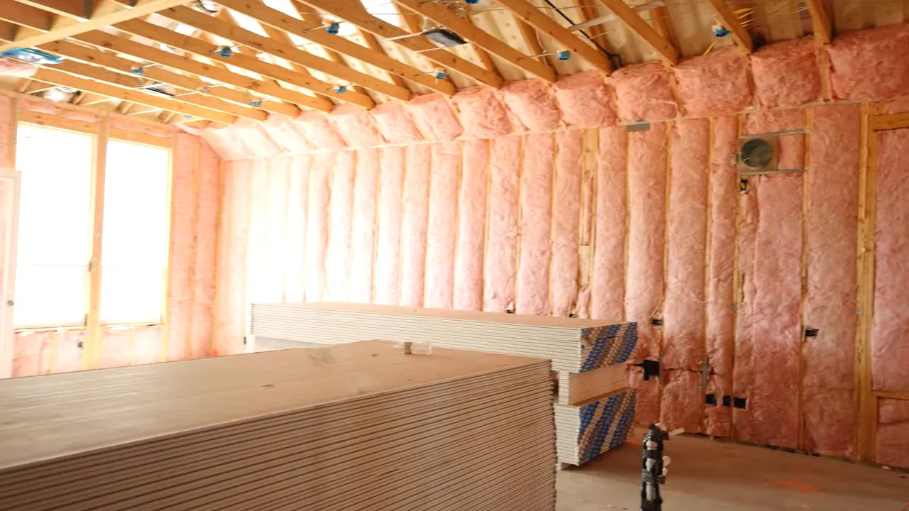 Attic framing and insulation details visible before drywall during home inspection