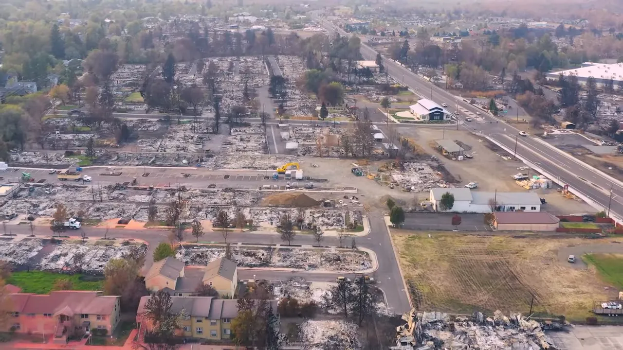 Aerial view of Phoenix Oregon Almeda Fire redevelopment site with cleared lots, construction vehicles, and nearby roads