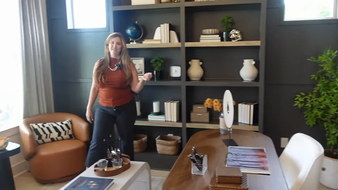 Home office with dark built-in shelves, desk, chair, and window seating