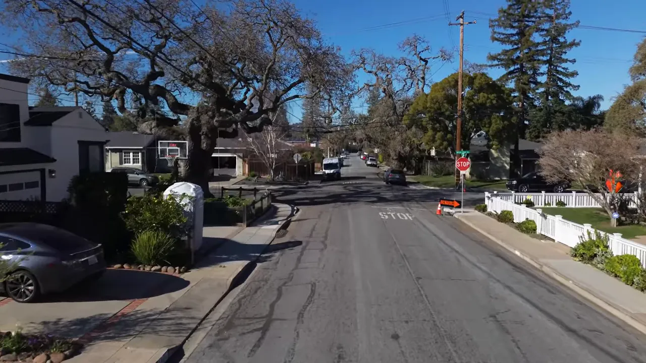 tree-lined flat residential street with sidewalks, stop sign and houses in San Carlos