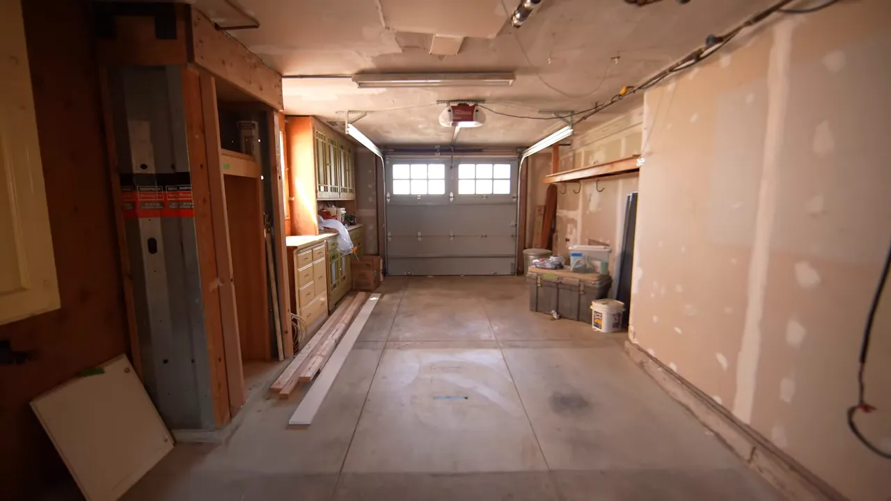 Wide, well-lit tandem garage interior showing storage cabinets, overhead opener and concrete floor
