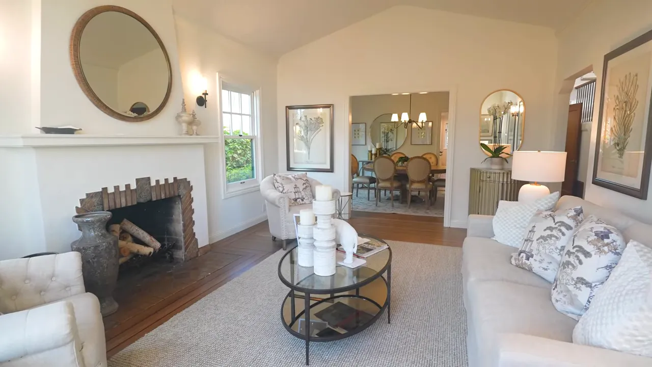 Living room showing original fireplace mantel, mouldings and hardwood floor border