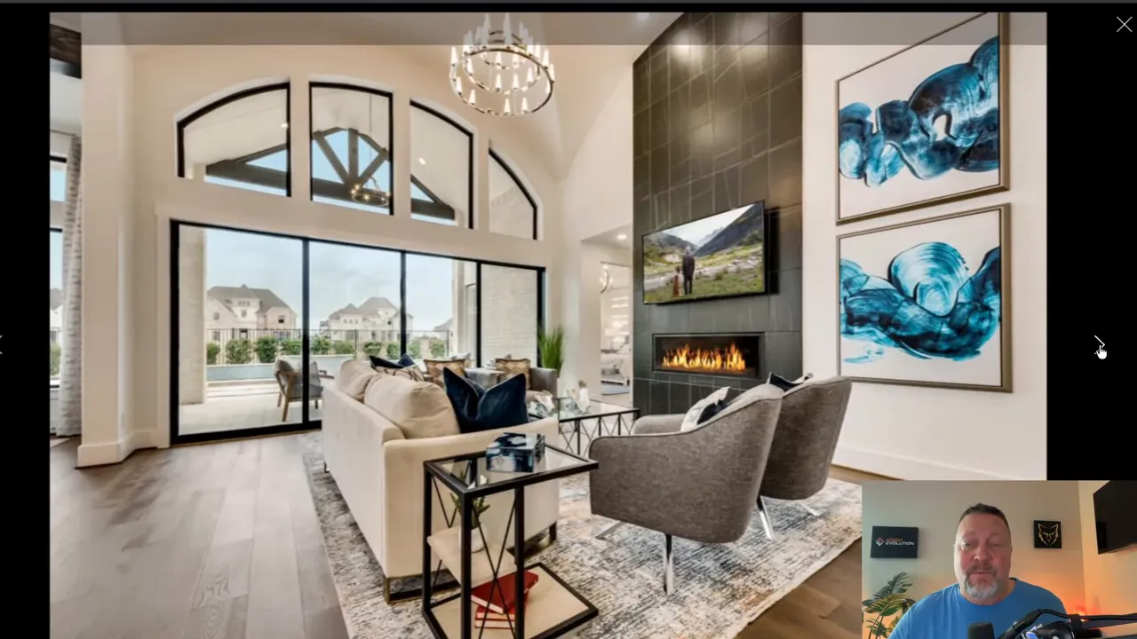 Bright two-story living room with large windows and fireplace in a Grand Home model at Creekside at Elevon, Lavon TX