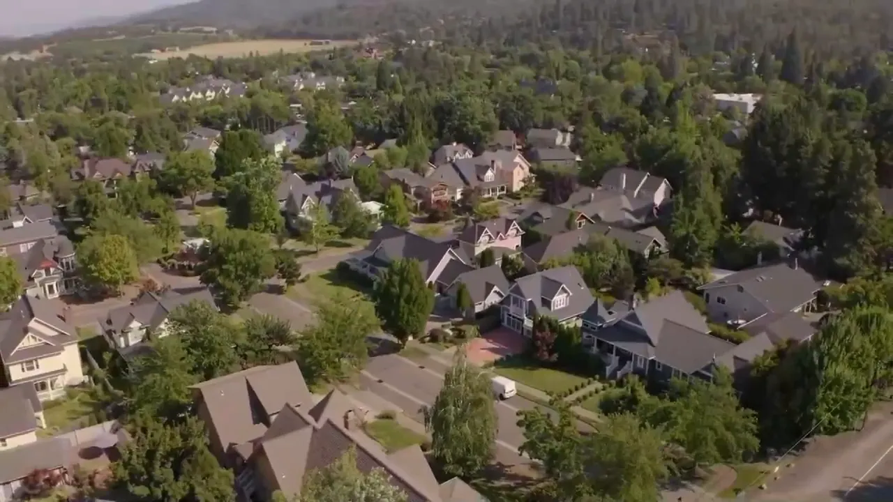 Wide aerial view of Jacksonville Oregon residential area with valley backdrop