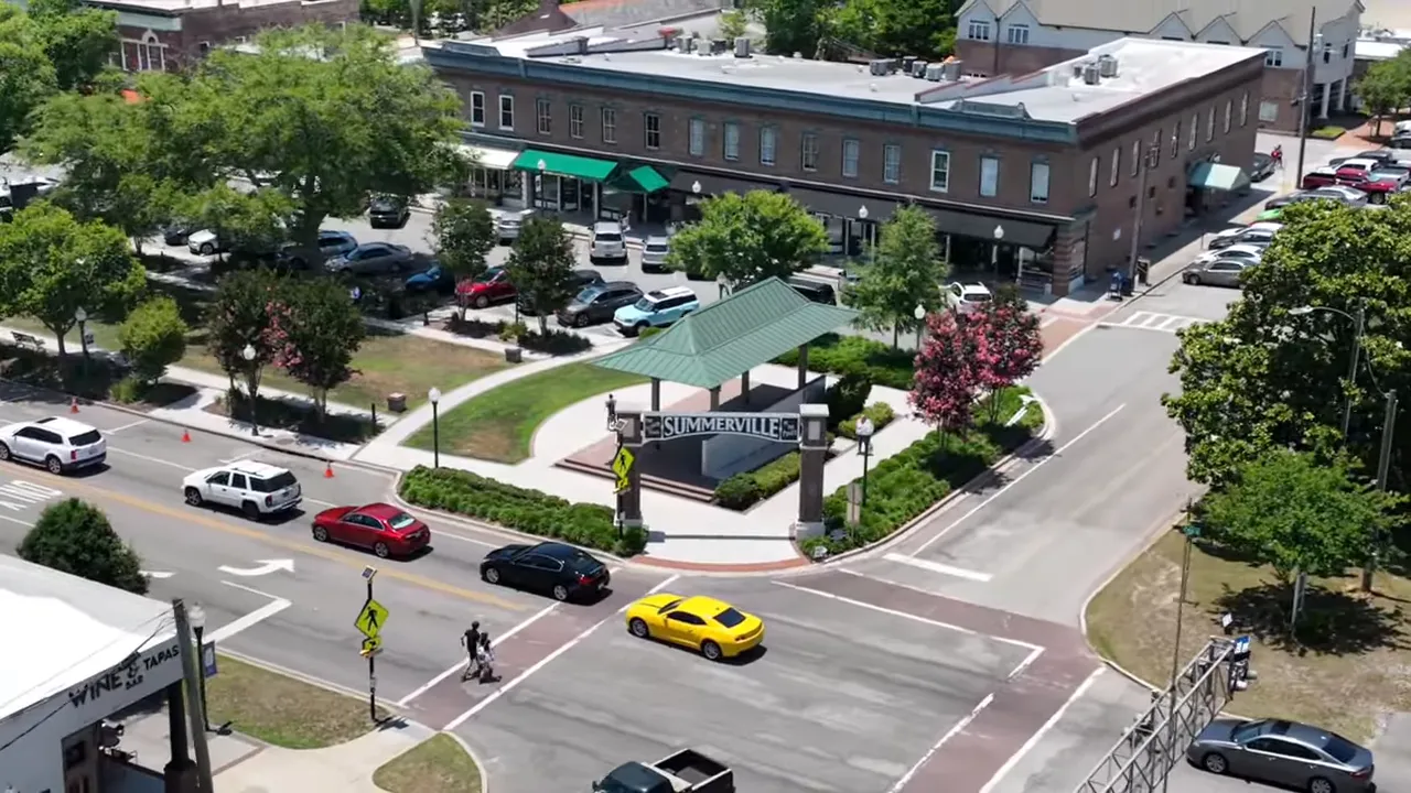 Aerial view of the Summerville town pavilion with the 'SUMMERVILLE' sign, surrounding streets, parked cars and storefronts.