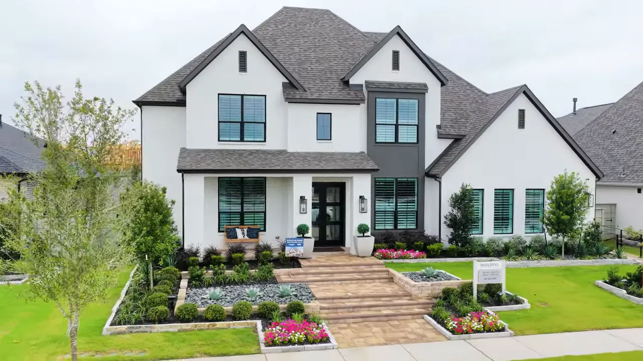 Front exterior of a white two story Highland model home with front porch and double doors